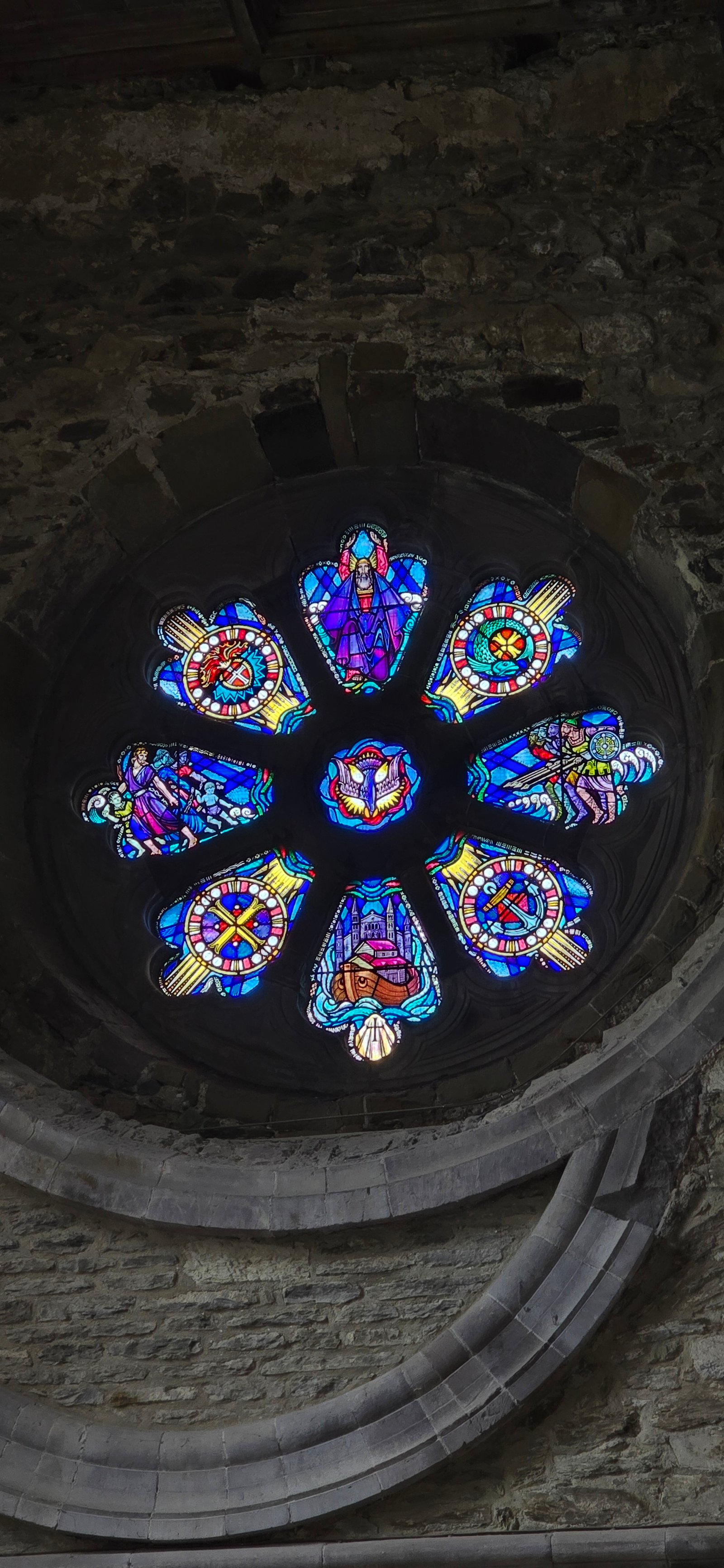Circular stained glass window in a stone church